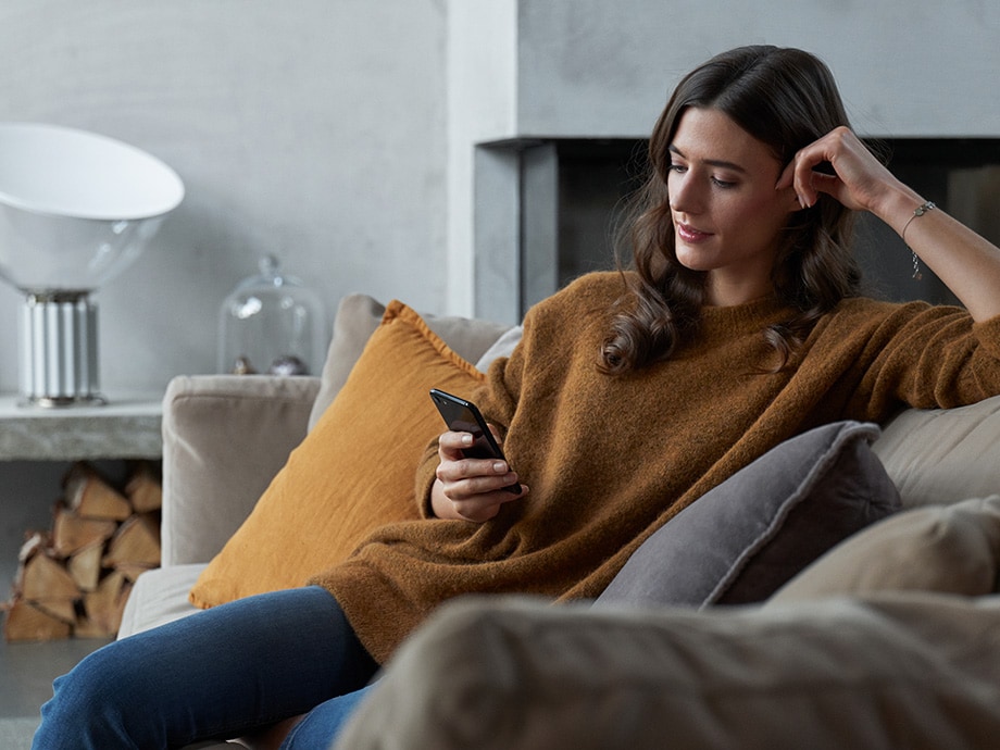 woman on couch with mobile phone